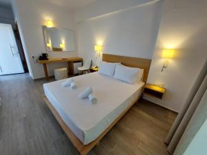 a bedroom with a large bed with white sheets and pillows at Blue Bay Hotel in Iraklitsa