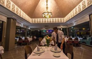 a man standing at a table in a restaurant at Riad Ommeyad Suite & Spa in Fès