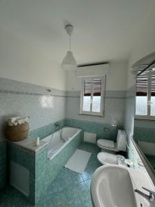 y baño con 2 aseos, bañera y lavamanos. en Cantu d'Amuri, en Avola 9 fotos más