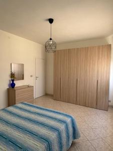 1 dormitorio con 1 cama con manta de rayas azules en Cantu d'Amuri, en Avola