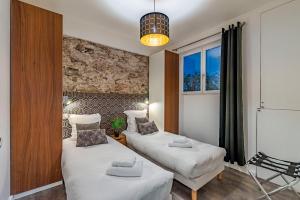 een kleine kamer met twee bedden en een raam bij Luxury Family 2BR - Prime Location, Walk to Beach & Shopping, Sunny Balcony - By Totolulu Cannes Hoche in Cannes
