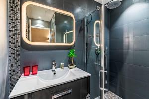 een badkamer met een wastafel en een spiegel bij Luxury Family 2BR - Prime Location, Walk to Beach & Shopping, Sunny Balcony - By Totolulu Cannes Hoche in Cannes