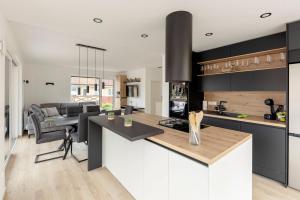 a kitchen with black and white cabinets and a living room at Apartment Božica in Ljubljana