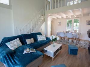 een woonkamer met een blauwe bank en een tafel bij Holiday Home Les Pins by Interhome in Pornic