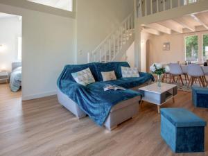 een woonkamer met een blauwe bank en een tafel bij Holiday Home Les Pins by Interhome in Pornic
