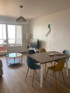 a living room with a dining room table and chairs at La Perle de Nacre in Courseulles-sur-Mer