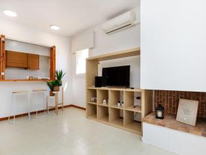 ein Wohnzimmer mit Fernseher und eine Küche in der Unterkunft Apartment Port Salanca by Interhome in Llança