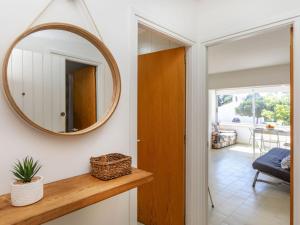 ein Spiegel an einer Wand neben einem Flur in der Unterkunft Apartment Port Salanca by Interhome in Llança