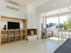 ein Wohnzimmer mit Fernseher und Tisch in der Unterkunft Apartment Port Salanca by Interhome in Llança + 14 Fotos