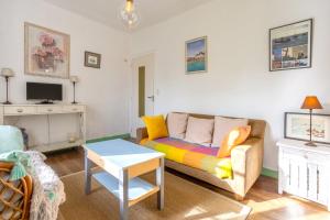 una sala de estar con un sofá y una mesa en Ferme Kerlan plage 5min en voiture, en Plobannalec-Lesconil