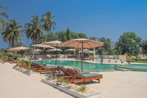 圣佩德罗Enotel Beach Hotel的一个带椅子和遮阳伞的游泳池