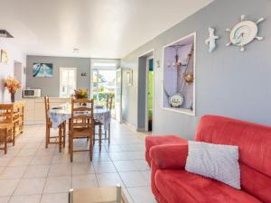 a living room with a red couch and a dining room at Holiday Home Villa la Fourmi by Interhome in Saint-Germain-sur-Ay