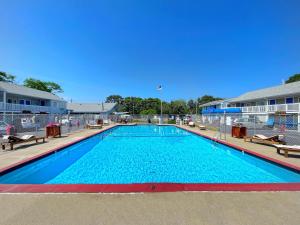 a large swimming pool with blue water in a building at Cape Sands Inn in West Yarmouth