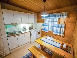 a kitchen with a table and a wooden wall at Holiday Home Heikkilä by Interhome in Kuusamo