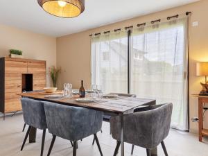 a dining room with a wooden table and chairs at Holiday Home Les sablons by Interhome in Agon Coutainville