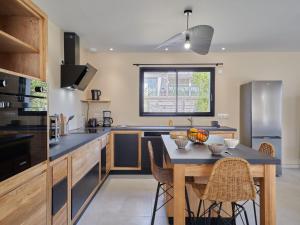 a kitchen with a table with chairs and a counter top at Holiday Home Les sablons by Interhome in Agon Coutainville +19 photos