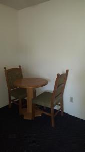 a wooden table and two chairs and a table and chairs sidx sidx sidx at Travelodge by Wyndham Indio in Indio