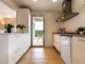 una cucina con armadi bianchi e una porta che conduce a un patio. di Holiday Home Patri by Interhome a L'Ampolla