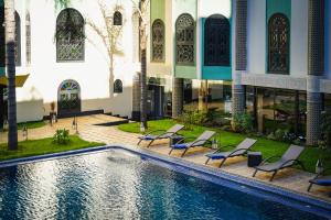 a pool in the courtyard of a building with lounge chairs at Riad Ommeyad Suite & Spa in Fez