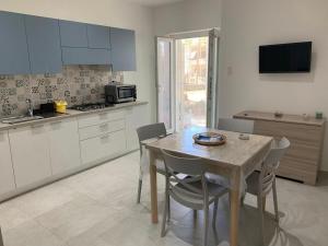 eine Küche mit einem Tisch und einigen Stühlen sowie einem Tisch und einem Tisch in der Unterkunft Il giglio di mare in Santa Maria di Castellabate + 1 Foto