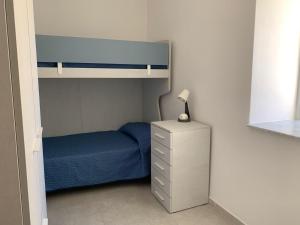 ein Schlafzimmer mit einem Etagenbett und eine Kommode mit einer Lampe in der Unterkunft Il giglio di mare in Santa Maria di Castellabate