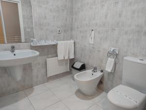 a white bathroom with a sink and a toilet at Motel Montecarlo in Teo