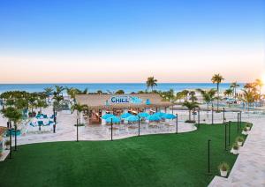 an aerial view of a resort with blue umbrellas and the ocean at Margaritaville Beach Resort Ft Myers Beach in Fort Myers Beach