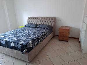 a bedroom with a bed with a blue and white comforter at CentroMare in Cattolica