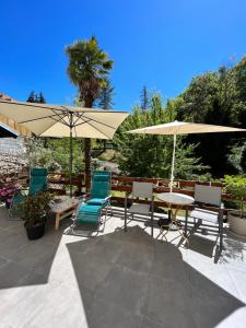 a patio with a table and chairs and umbrellas at Villa Julia in Capvern