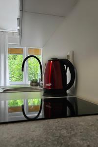 a red tea kettle sitting on a counter in a kitchen at Marigold in Rijeka