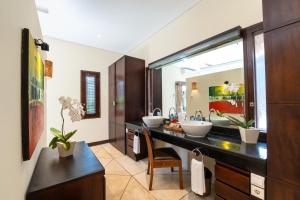 ein Badezimmer mit zwei Waschbecken und einem großen Spiegel in der Unterkunft The Maya Seminyak Villas in Seminyak
