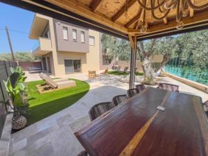 a large wooden table and chairs on a patio at Villa Nous luxury in Skala Sotiros