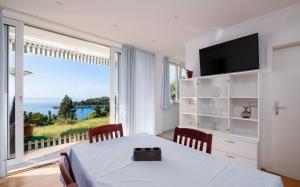 ein Esszimmer mit einem Tisch und einem großen Fenster in der Unterkunft Apartments Katica in Mlini