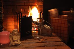 a table with wine glasses and a book and a fireplace at Hotel Sandhof in Lech am Arlberg