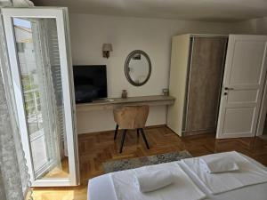 een slaapkamer met een bed, een spiegel en een televisie bij House Tereza in Vodice