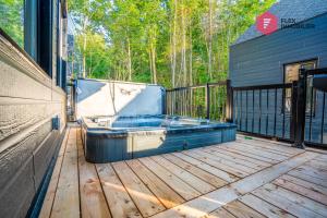 una vasca idromassaggio su una terrazza in legno di The Blue Pearl of Portneuf - Private hot tub Pool Trails Billiards a Pont-Rouge
