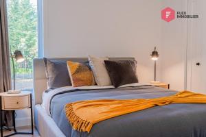 una camera da letto con un letto con una coperta arancione sopra di The Blue Pearl of Portneuf - Private hot tub Pool Trails Billiards a Pont-Rouge