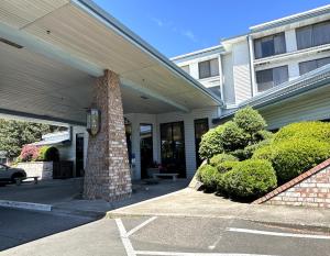 a house with a porch with a pillar and bushes at Sojourn Suites Portland Airport in Portland