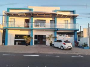 a white car parked in front of a building at Hotel Barruada in Boa Vista