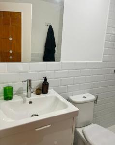 Un baño blanco con inodoro y lavabo. en Villa Cabárceno, en Cabárceno 3 fotos más
