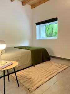Un dormitorio con una cama y una mesa y una ventana. en Villa Cabárceno, en Cabárceno