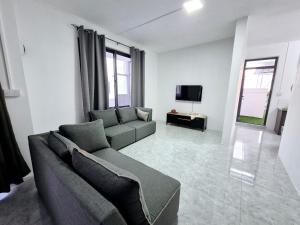 a living room with a couch and a tv at Skyview Apartment- Rooftop Penthouse with Sunset & Sea Views in Flic-en-Flac
