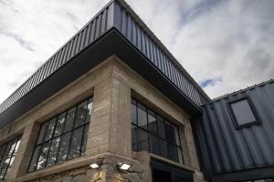 an office building with a black roof and windows at L'atelier de 1900 in Puicheric