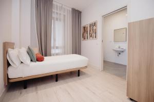 a white room with a bed and a sink at Aspasios Atocha Apartments in Madrid