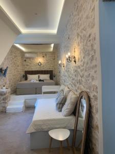 a bedroom with two beds and a stone wall at Amor Fati in Amfilochia