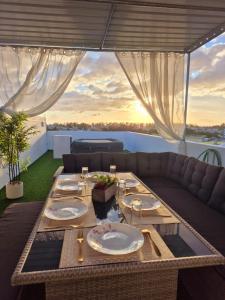a dining table on a balcony with a view of the ocean at Skyview Apartment- Rooftop Penthouse with Sunset & Sea Views in Flic-en-Flac