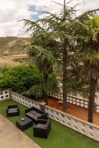 a garden with benches and trees and a fence at Vivienda Rural Casa del Medico in Castejón de Valdejasa