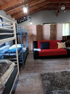 a room with a red couch and a bunk bed at Chata na Rogu in Boszkowo-Letnisko