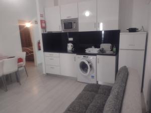 a kitchen with a washing machine and a microwave at Casinhas de Alfenim in Sesimbra