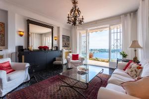 a living room with white furniture and a large window at ROMANTIC VILLA VI4412 By Riviera Holiday Homes in Villefranche-sur-Mer